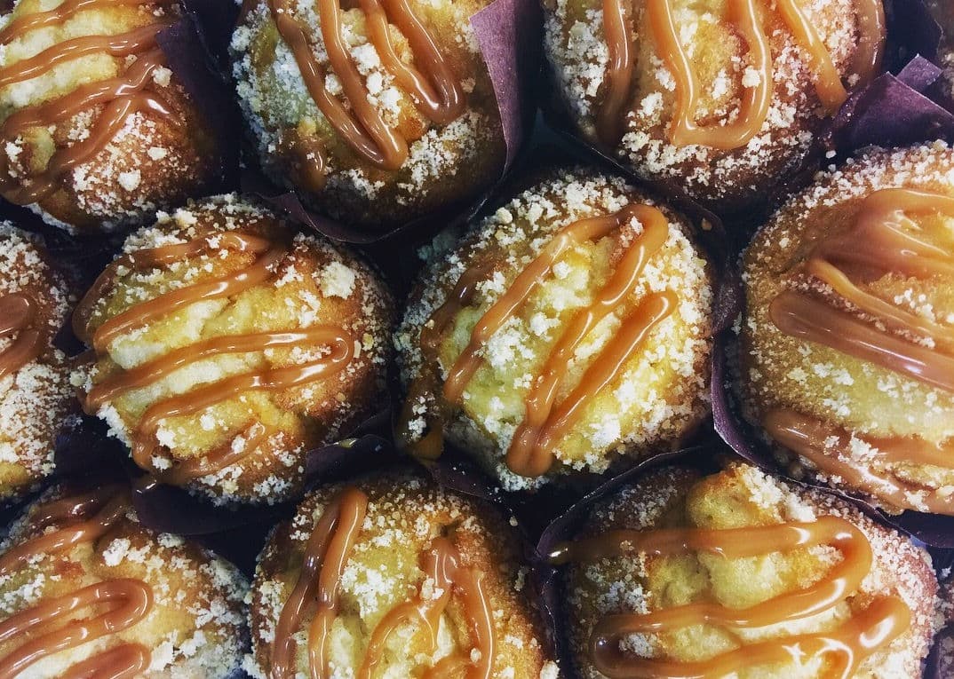 A cluster of large freshly baked muffins with domed golden tops.