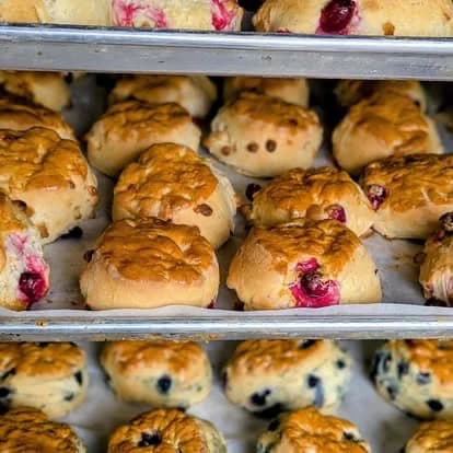 Mixed scones on metal bakery trays.