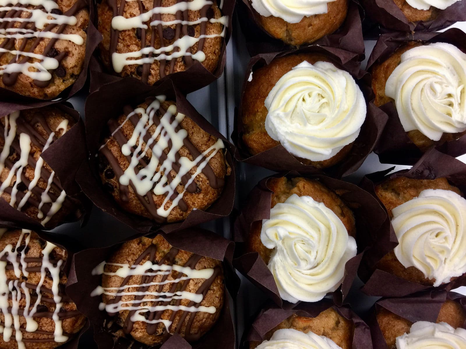 Decorated muffins and cupcakes in paper cases.
