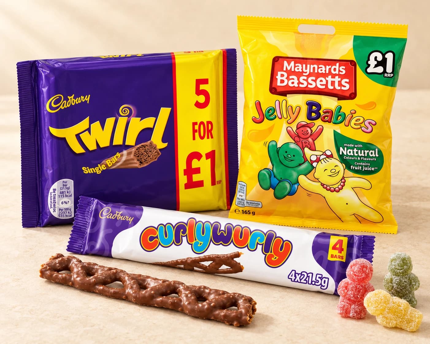 Cadbury Twirl and Curly Wurly packs with Maynards Bassetts Jelly Babies, a chocolate bar and loose sweets on a cream tabletop.