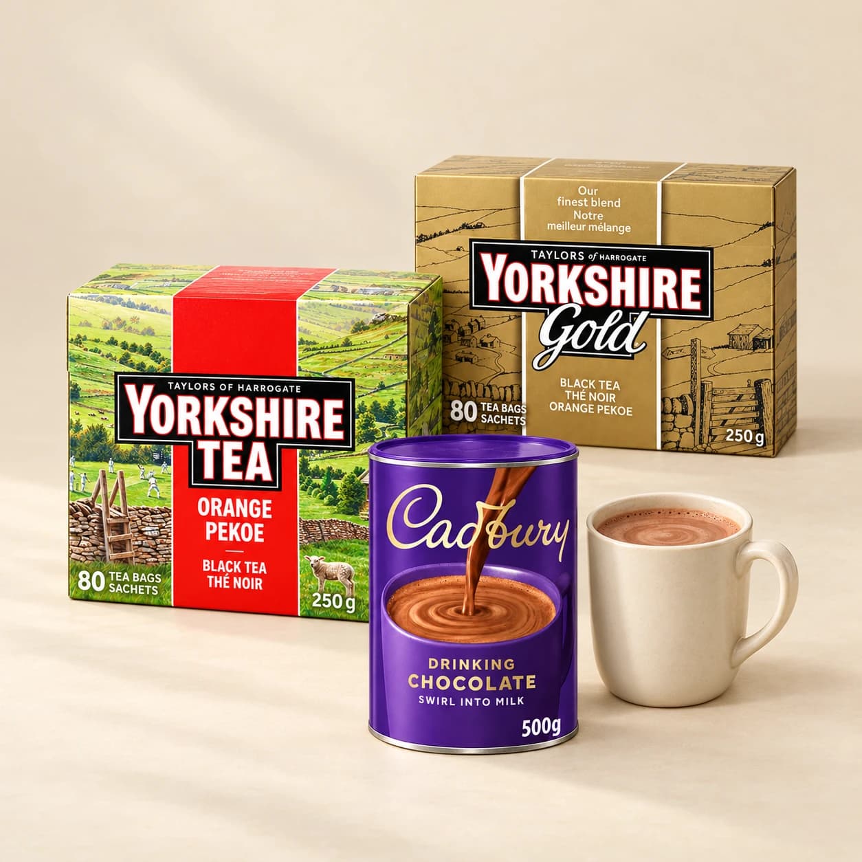 Yorkshire Tea and Yorkshire Gold boxes with Cadbury Drinking Chocolate and a cream mug on a cream tabletop.